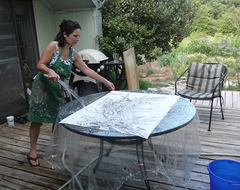 The water cure. There's a shower curtain over the patio table to puddle water on. The idea is to wash off the loose graphite and get the paper REALLY well soaked.